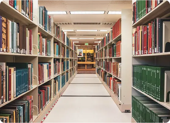 Smartphone, glasses, and pens on a desk with open magazines and notes.