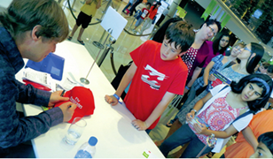 أطفال يقفون في طابور طويل بانتظار الحصول على توقيع كاتبهم المفضل البريطاني نيك أرنولد ضمن أنشطة مهرجان طيران الإمارات للآداب