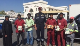 مواطنة توزع كتباً للعمال في رأس الخيمة